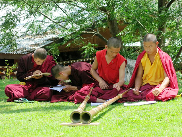 Dezenas de monges estavam tendo aula de música para entoar a longa corneta tibetana.. Foto: Karina e Pablo