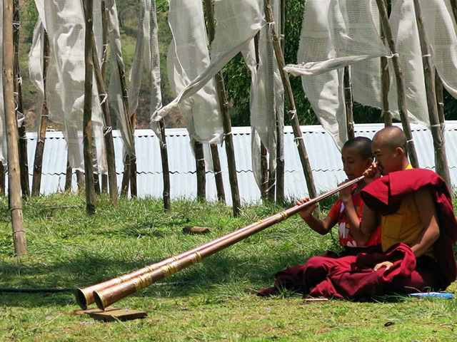 Dezenas de monges estavam tendo aula de música para entoar a longa corneta tibetana.. Foto: Karina e Pablo