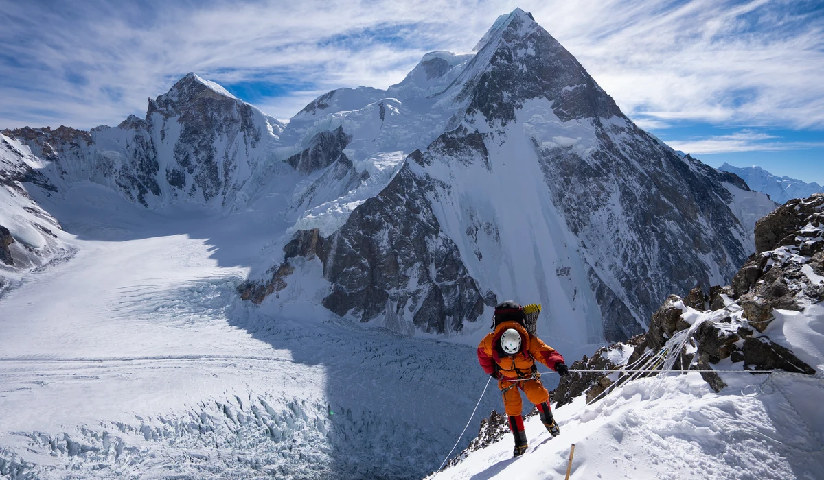 Alpinista avança por uma encosta nevada